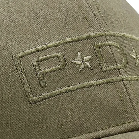 Nærbilde av brodert logo på caps