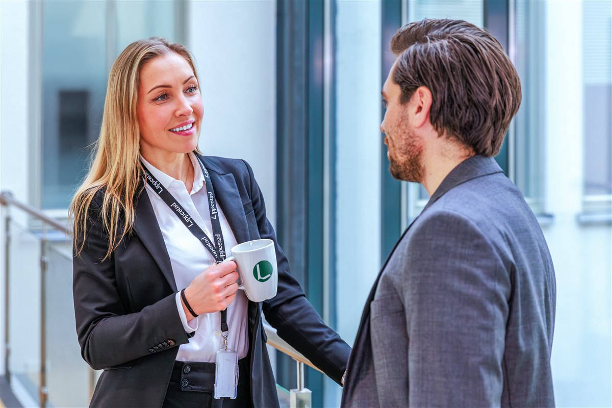 Ansatt med profilert kaffekopp med logo