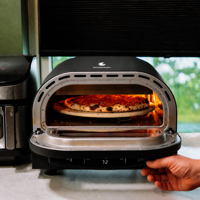 Pizza steker i pizzaovnen med glødende varmeelement