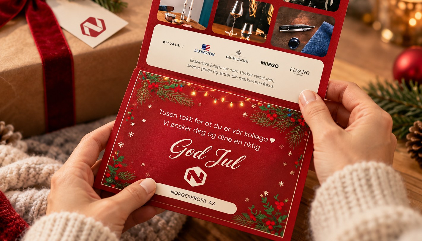 Hender som holder et julegavekort fra NorgesProfil med «God Jul»-hilsen, med en innpakket gave og julelys i bakgrunnen