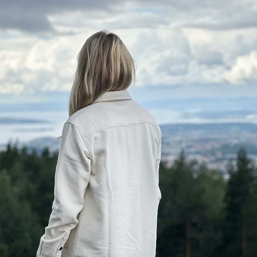 Kvinne i Tufte Hawk-overskjorte ser ut over fjorden